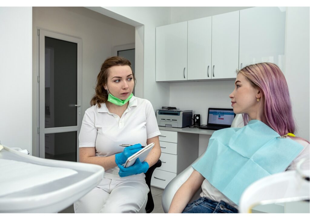 Dentist explaining dental implant treatment and cost to patient in dental office.