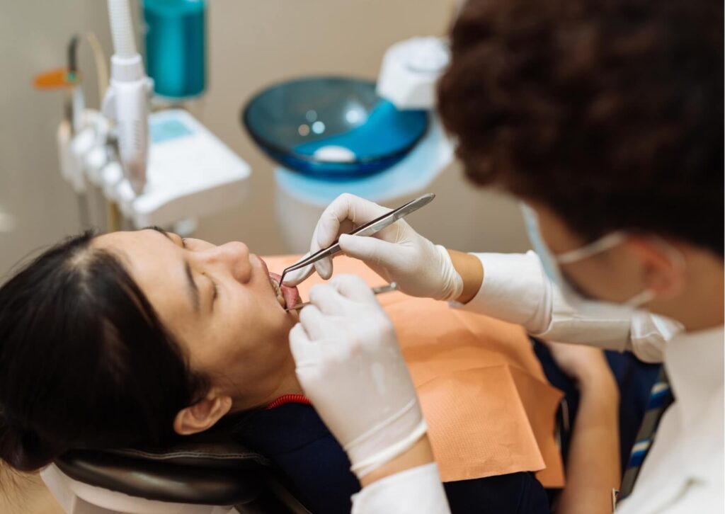 Dentist performing a root canal procedure on a patient, highlighting factors that may affect whether it is safe to drive after treatment.