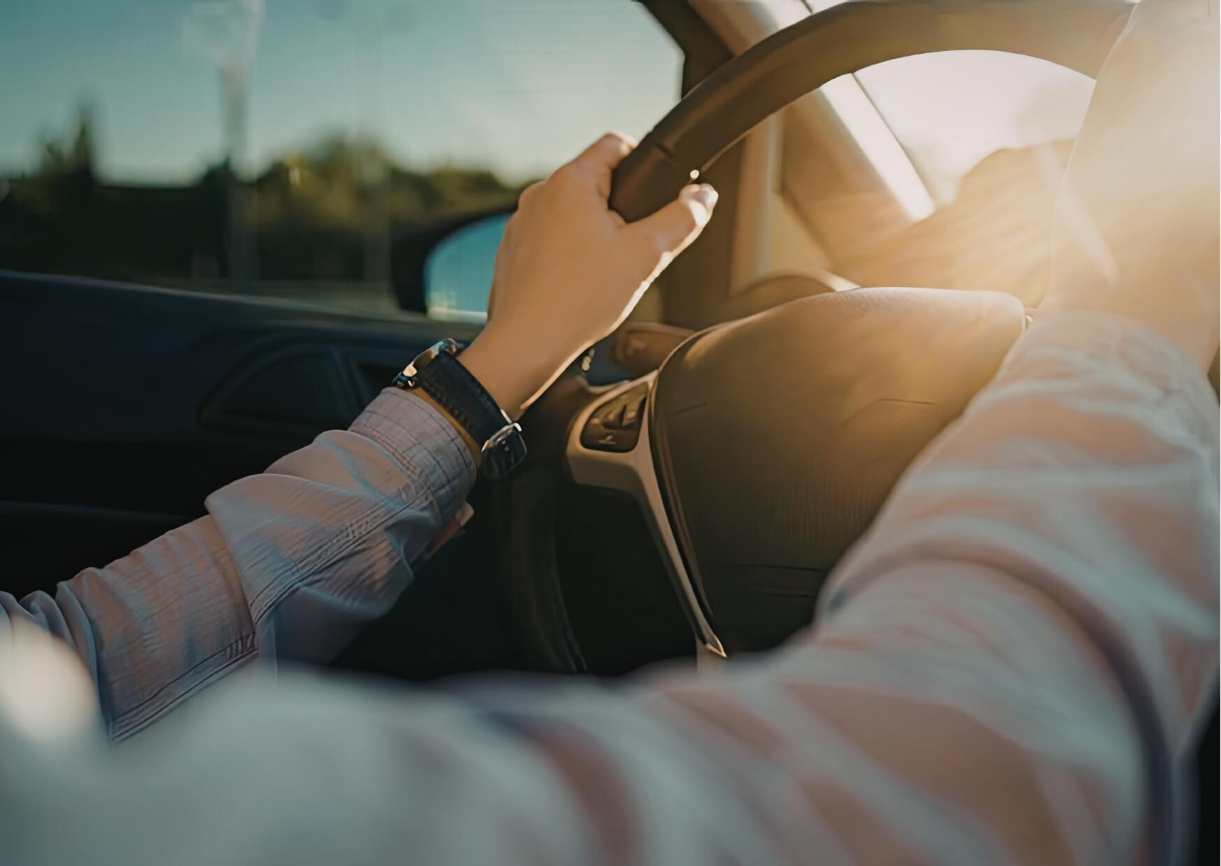 Driver holding the steering wheel after a dental appointment, illustrating considerations about driving after a root canal treatment.