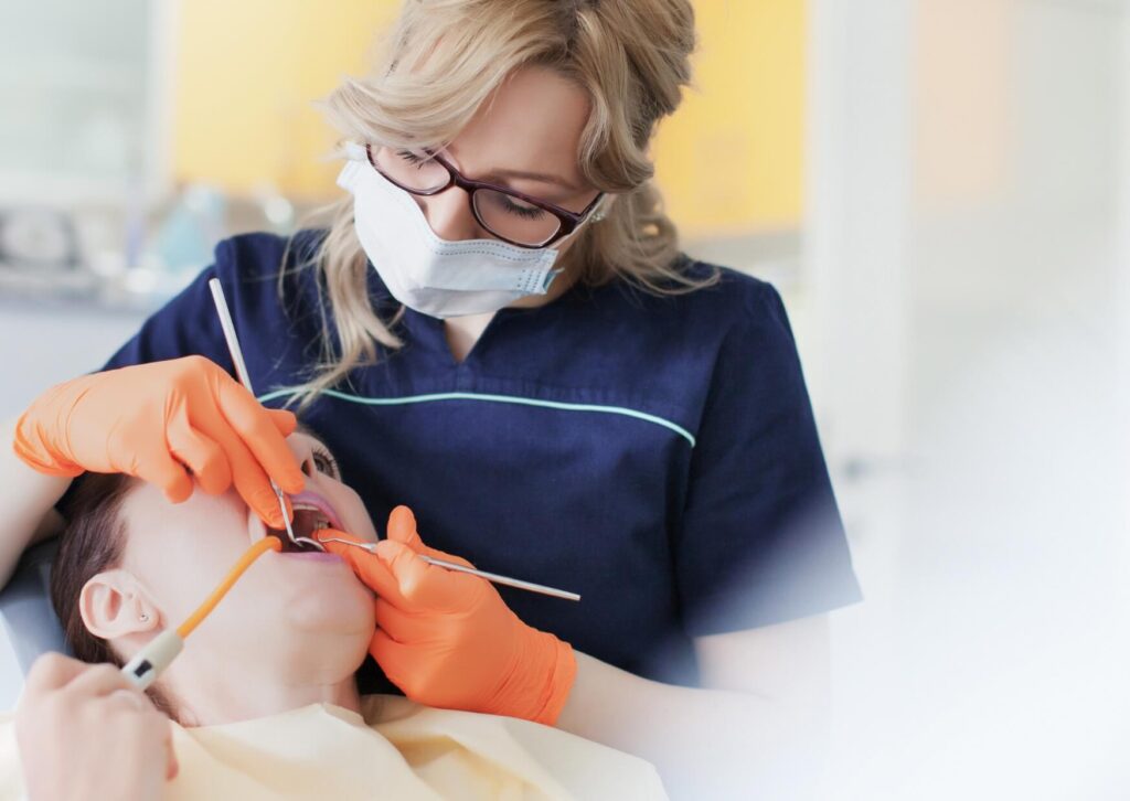 Dentist examining a patient during a procedure to assess a failing dental implant and determine whether dental implant removal is necessary.