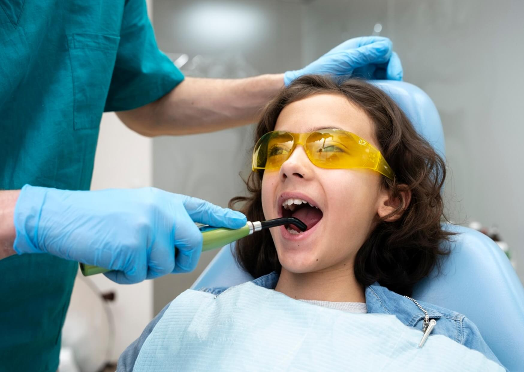 Dentist examining a child's teeth before placing a dental spacer to preserve space for incoming permanent teeth.