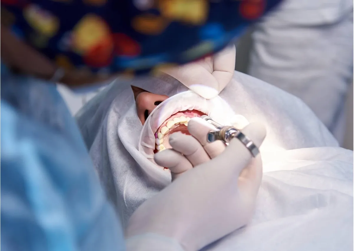 Dental professional performing gum contouring treatment to reshape the gumline around the teeth.