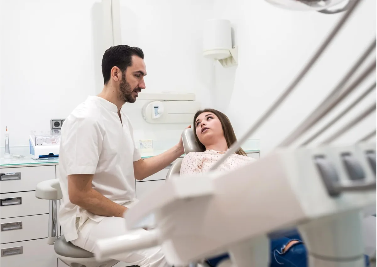Dentist discussing gum contouring treatment with a patient during a cosmetic dental consultation.