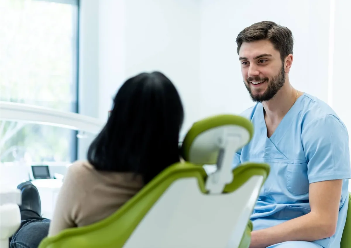 Dentist discussing persistent dry mouth symptoms and treatment options with a patient.