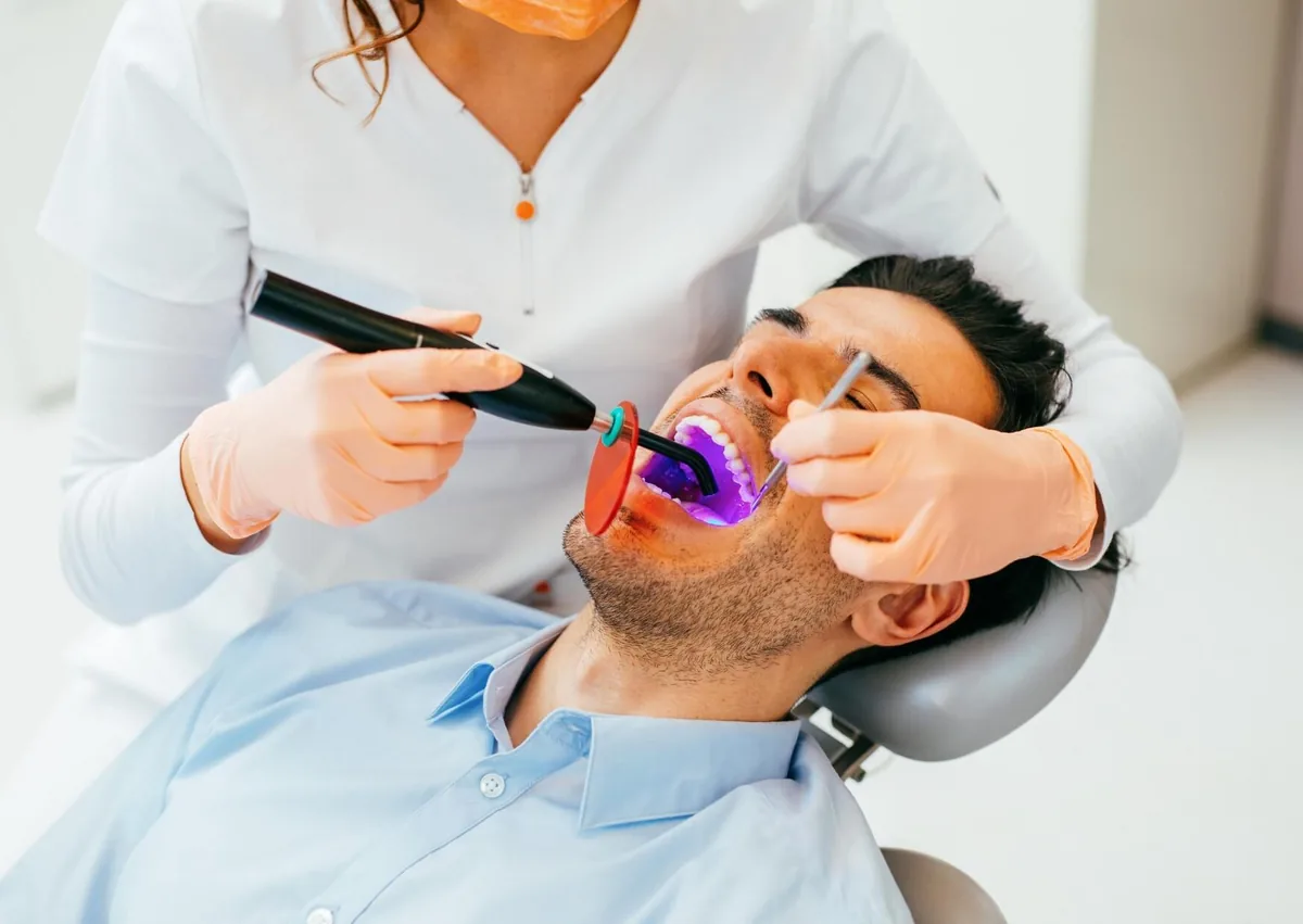 Patient receiving composite resin treatment as part of a dental bonding procedure.